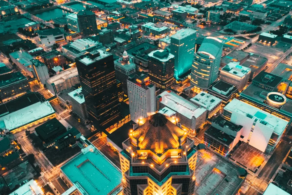 drone footage of downtown Des Moines with radiant city lights at dusk